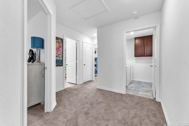 hall with washer and dryer, baseboards, carpet floors, and attic access