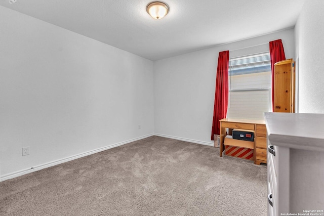 carpeted spare room featuring baseboards