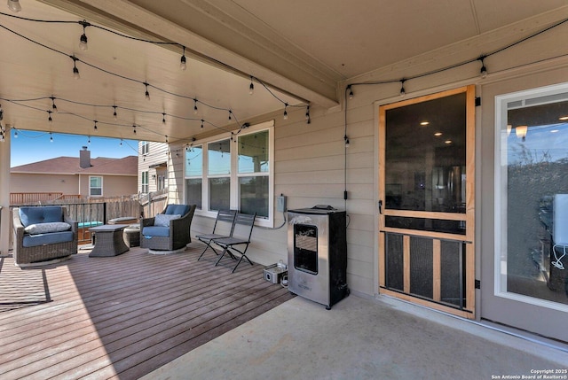 deck featuring heating unit and an outdoor fire pit