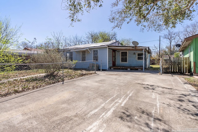 view of front facade featuring concrete driveway and fence