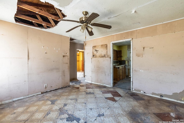 empty room with tile patterned floors and a ceiling fan