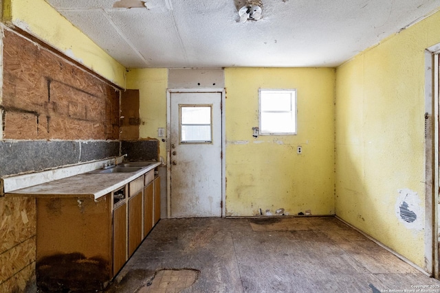 kitchen with a sink, brown cabinets, and a textured ceiling