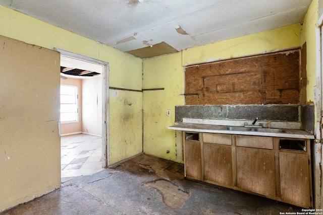 kitchen featuring a sink, brown cabinets, and light countertops