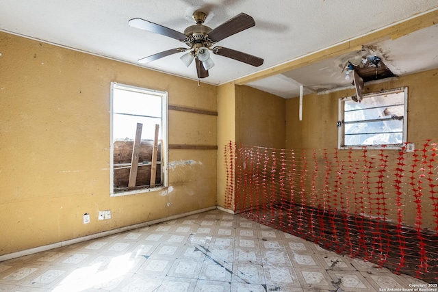 unfurnished room with tile patterned floors, baseboards, and a ceiling fan