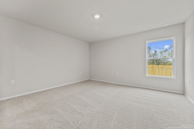 carpeted empty room featuring baseboards