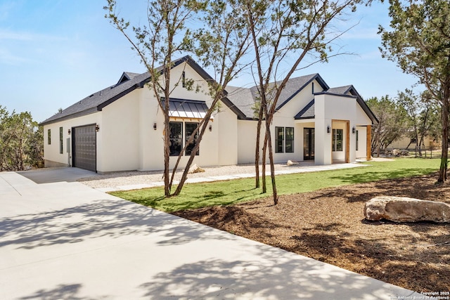 view of front of home with a garage, concrete driveway, and stucco siding