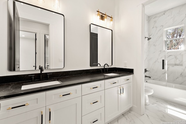 bathroom featuring double vanity, toilet, marble finish floor, and a sink