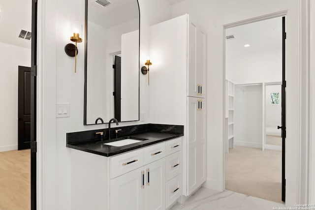 bathroom with vanity, visible vents, baseboards, and marble finish floor