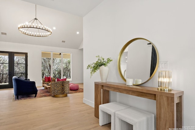 foyer with visible vents, baseboards, french doors, wood finished floors, and high vaulted ceiling