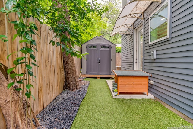 view of yard with an outbuilding, a storage unit, and fence