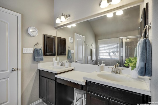 bathroom with a sink, lofted ceiling, a shower stall, and double vanity