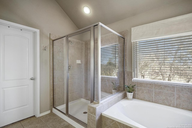 bathroom featuring tile patterned flooring, a shower stall, a garden tub, and lofted ceiling