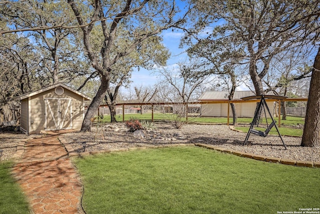 view of yard featuring an outbuilding, a storage unit, and fence