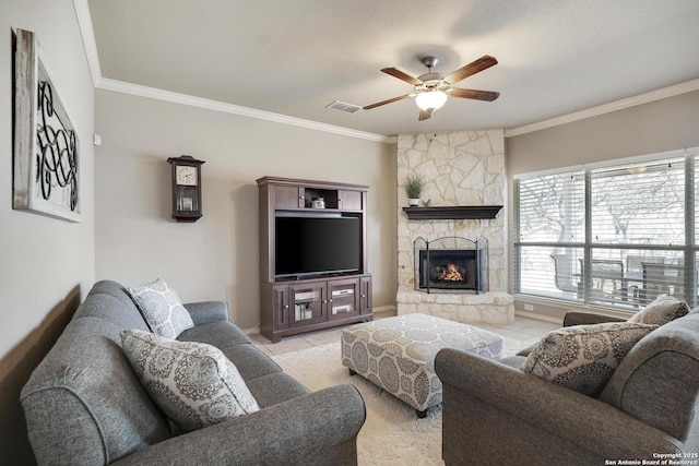 living room featuring visible vents, ornamental molding, a fireplace, tile patterned floors, and a ceiling fan