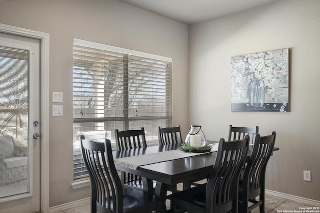 tiled dining space featuring baseboards