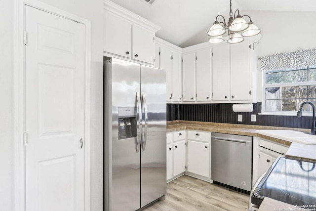 kitchen featuring a sink, stainless steel appliances, light wood-style flooring, and white cabinetry