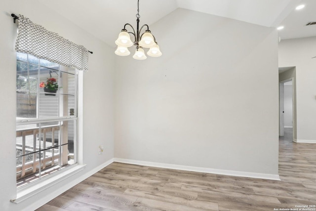 unfurnished dining area with visible vents, lofted ceiling, wood finished floors, baseboards, and a chandelier