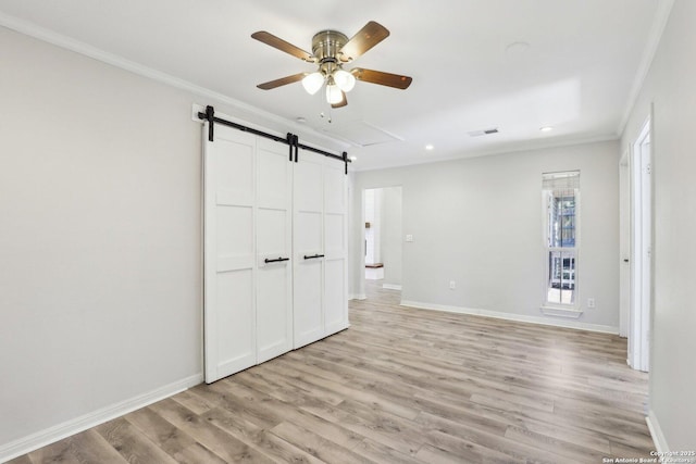 unfurnished bedroom featuring visible vents, light wood-type flooring, baseboards, and ornamental molding