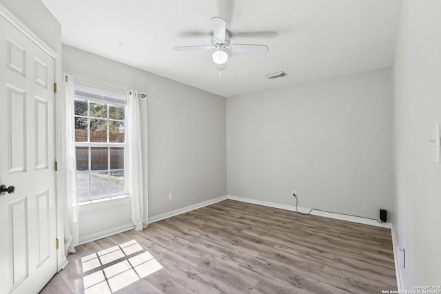 empty room with visible vents, baseboards, wood finished floors, and a ceiling fan