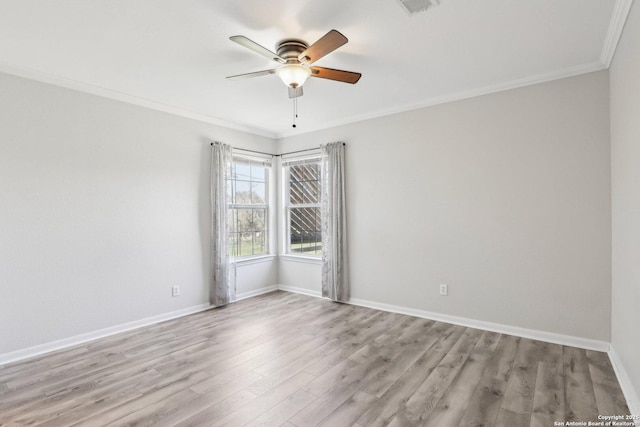 empty room with visible vents, light wood-style flooring, crown molding, baseboards, and ceiling fan