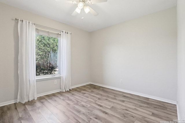 empty room with baseboards, wood finished floors, and a ceiling fan