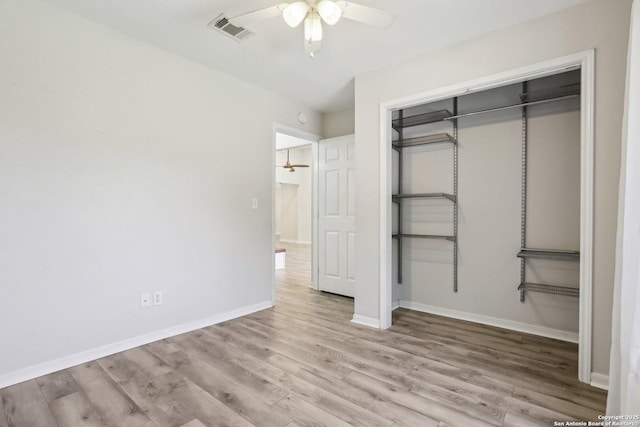 unfurnished bedroom featuring visible vents, a ceiling fan, wood finished floors, a closet, and baseboards