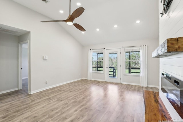 unfurnished living room featuring visible vents, a large fireplace, wood finished floors, high vaulted ceiling, and a ceiling fan