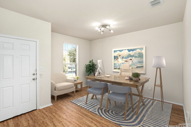 office area with visible vents, baseboards, and wood finished floors