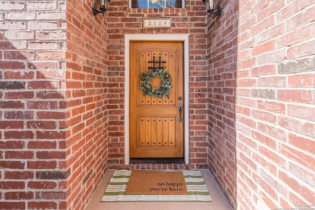 entrance to property featuring brick siding