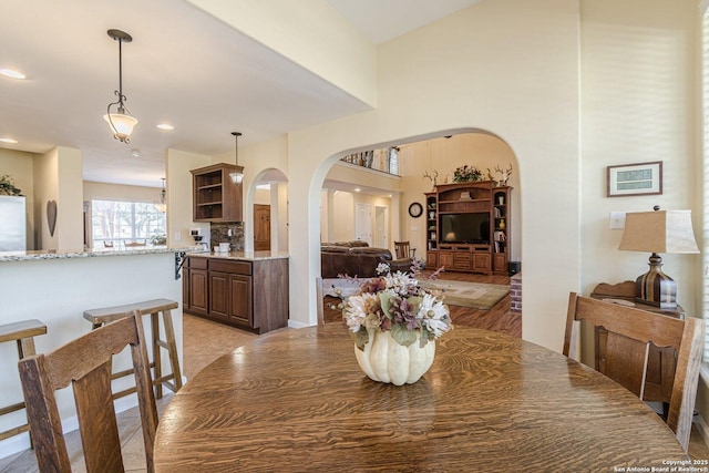 dining area with recessed lighting and arched walkways