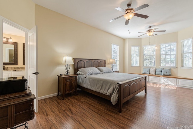 bedroom with wood finished floors, baseboards, and ensuite bathroom