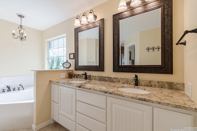 full bath featuring double vanity, a notable chandelier, a garden tub, and a sink