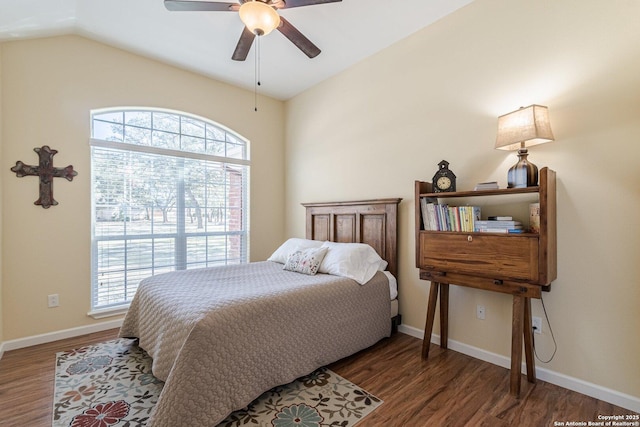 bedroom with multiple windows, wood finished floors, and vaulted ceiling