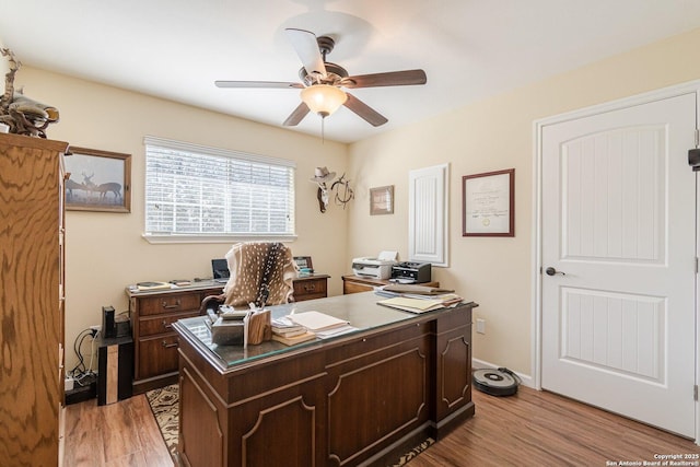 office space featuring light wood-style flooring, baseboards, and ceiling fan