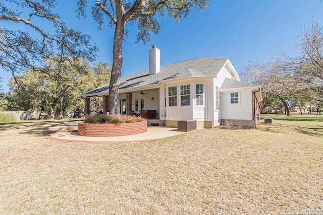 back of house with ceiling fan, central AC, a chimney, a yard, and a patio