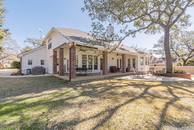 rear view of property with a ceiling fan, french doors, a lawn, a patio area, and brick siding