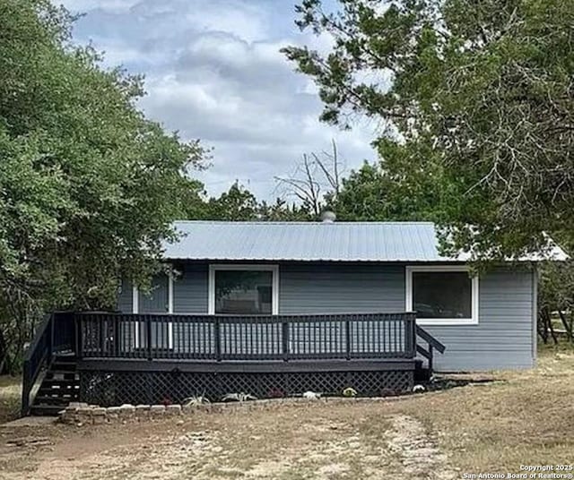 rear view of property with a wooden deck and metal roof