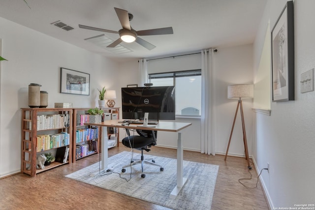 office space featuring visible vents, ceiling fan, baseboards, and wood finished floors