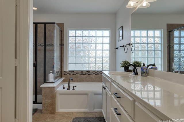 full bathroom featuring tile patterned flooring, a stall shower, vanity, and a bath