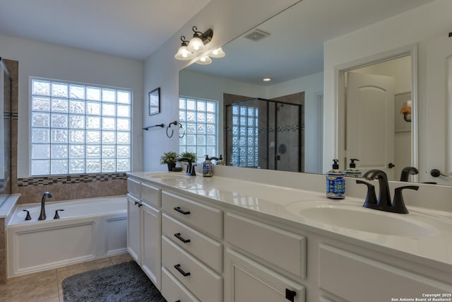 full bathroom featuring tile patterned floors, a stall shower, visible vents, and a sink