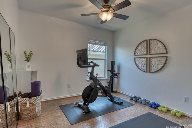 exercise area featuring wood finished floors, baseboards, and ceiling fan