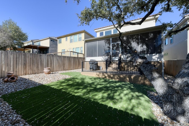 view of yard with a fenced backyard and a sunroom