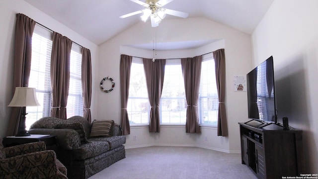 living room with a ceiling fan, lofted ceiling, light colored carpet, and baseboards