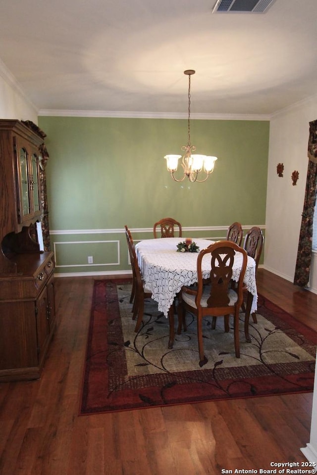 dining area with visible vents, a notable chandelier, dark wood-style floors, and crown molding