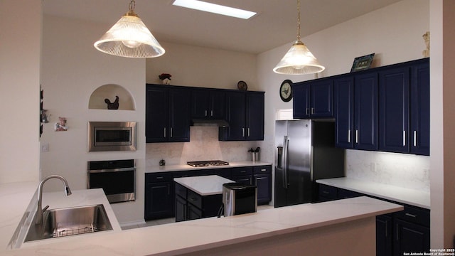 kitchen featuring a sink, under cabinet range hood, a center island, appliances with stainless steel finishes, and decorative backsplash