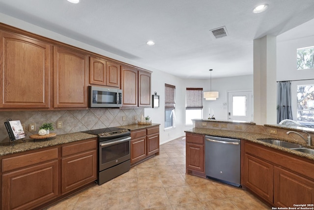 kitchen featuring visible vents, brown cabinets, tasteful backsplash, and appliances with stainless steel finishes