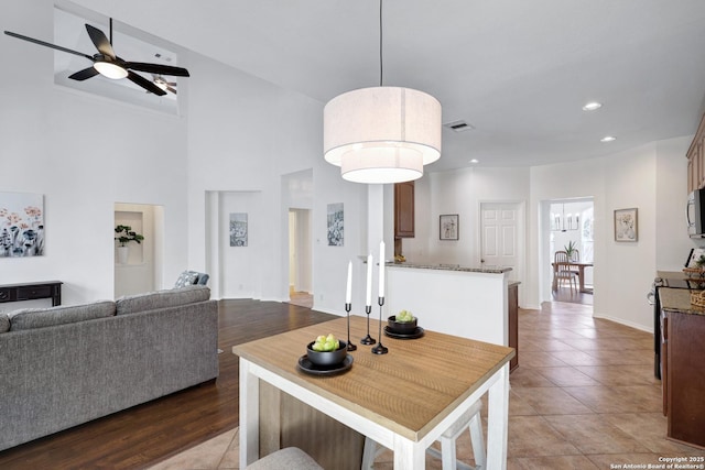 dining space with visible vents, ceiling fan, light tile patterned floors, recessed lighting, and a high ceiling