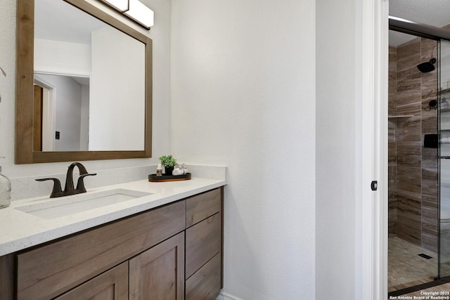 bathroom with a shower stall and vanity