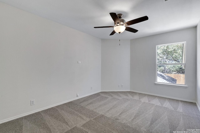 carpeted spare room featuring a ceiling fan and baseboards