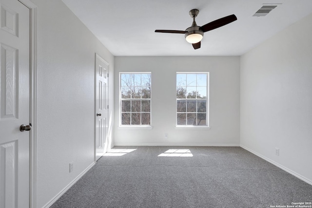 empty room featuring visible vents, baseboards, carpet, and a ceiling fan